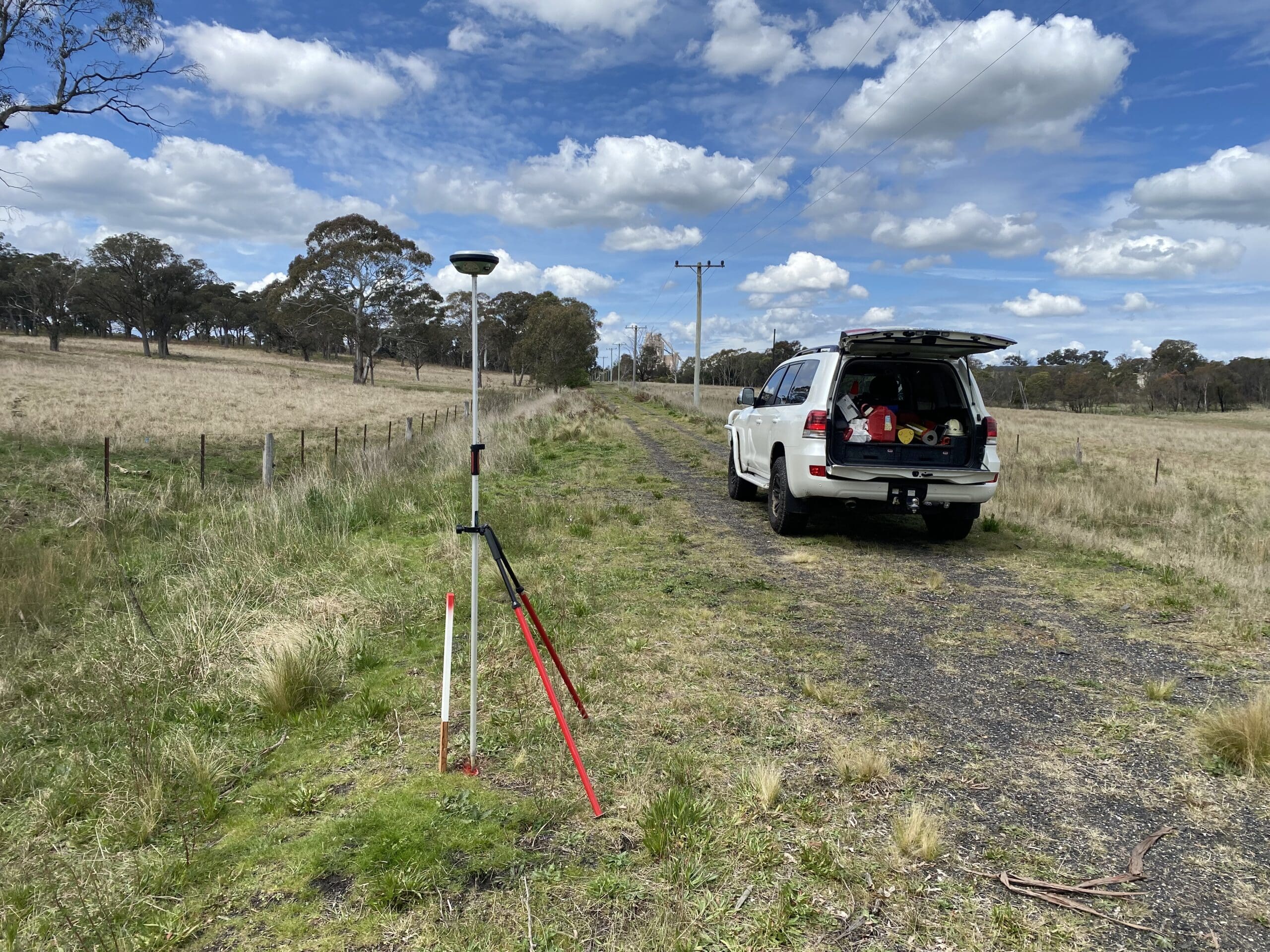 IMG_2022 GNSS receiver on a tripod over a survey control mark beside a rural road