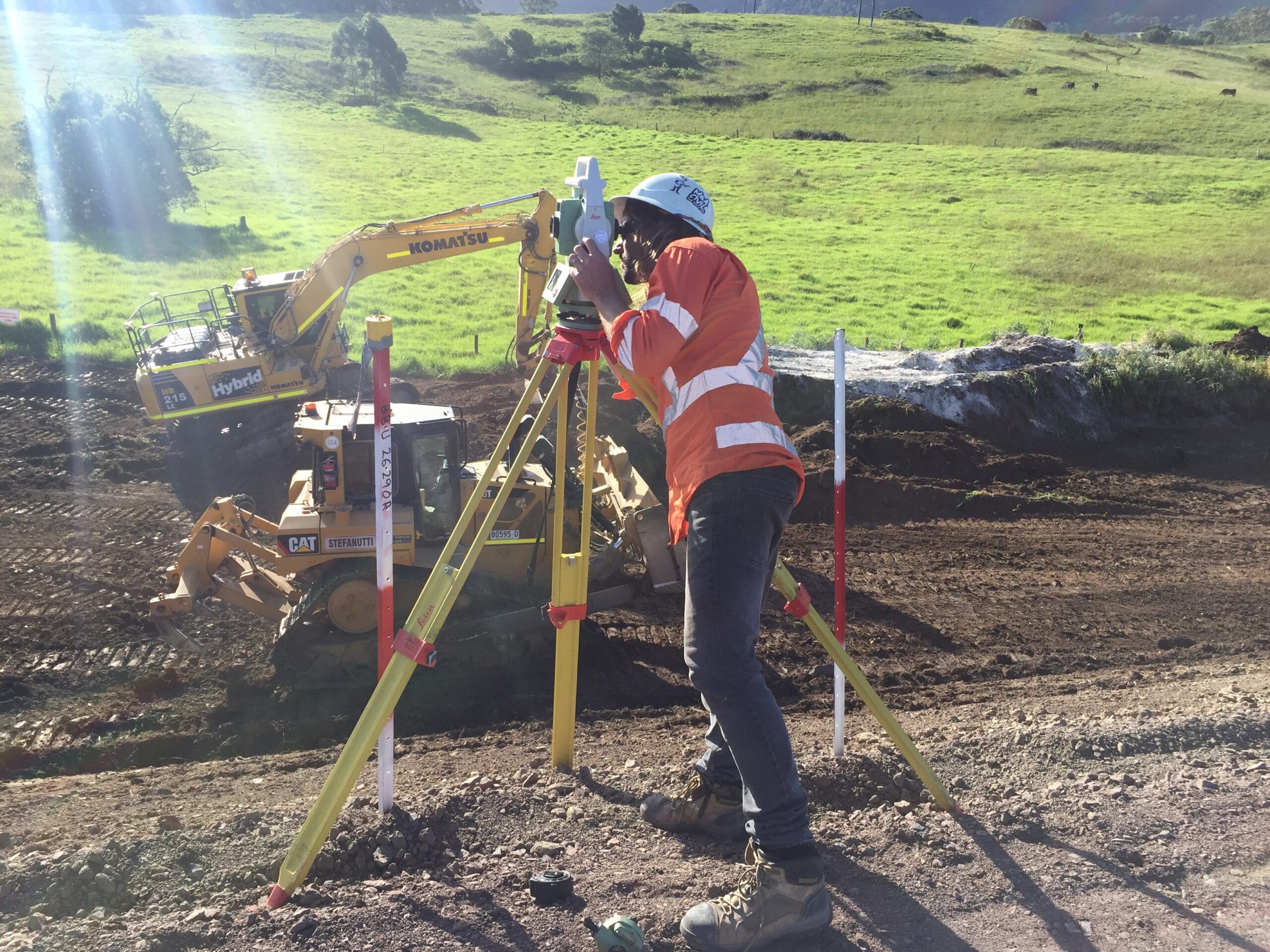 IMG_5824 Surveyor at a total station beside pink setout pegs on a civil earthworks site